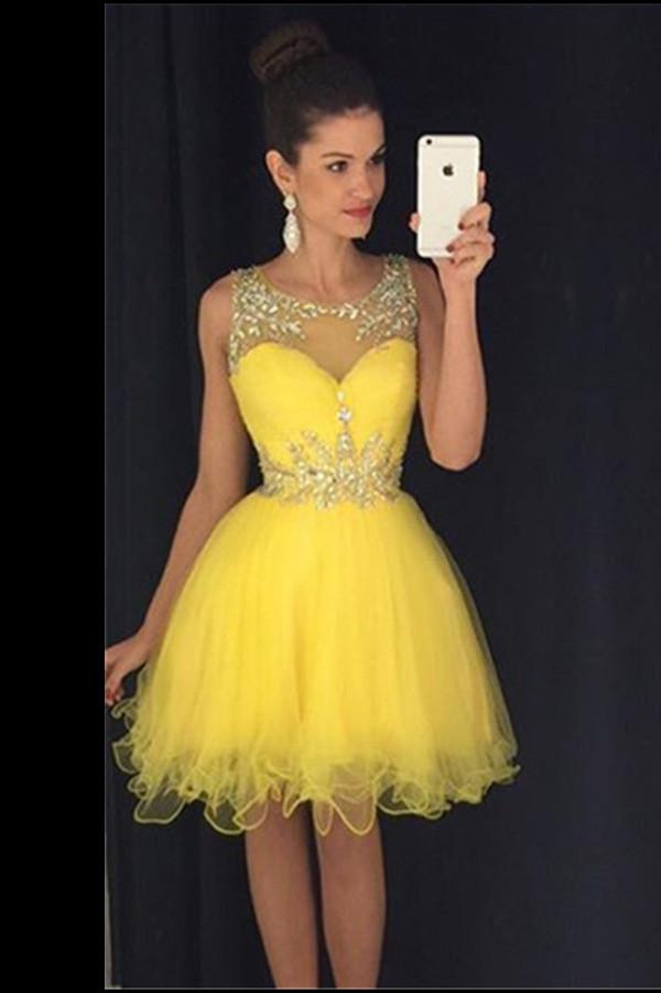 A woman in a yellow tulle dress with a sweetheart neckline and sequin embellishments taking a selfie.