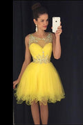 A woman in a yellow tulle dress with a sweetheart neckline and sequin embellishments taking a selfie.
